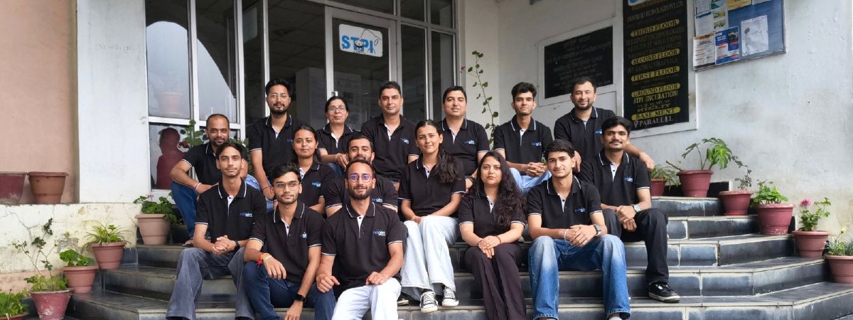 The Netgen team, about twenty people in matching black shirts, seated on the entrance steps of the STPI building in Kasumpti, Shimla