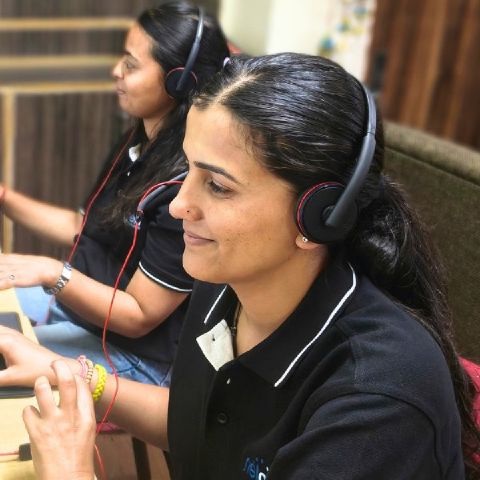 Two Netgen staff wearing headsets working at their desks in the Shimla office