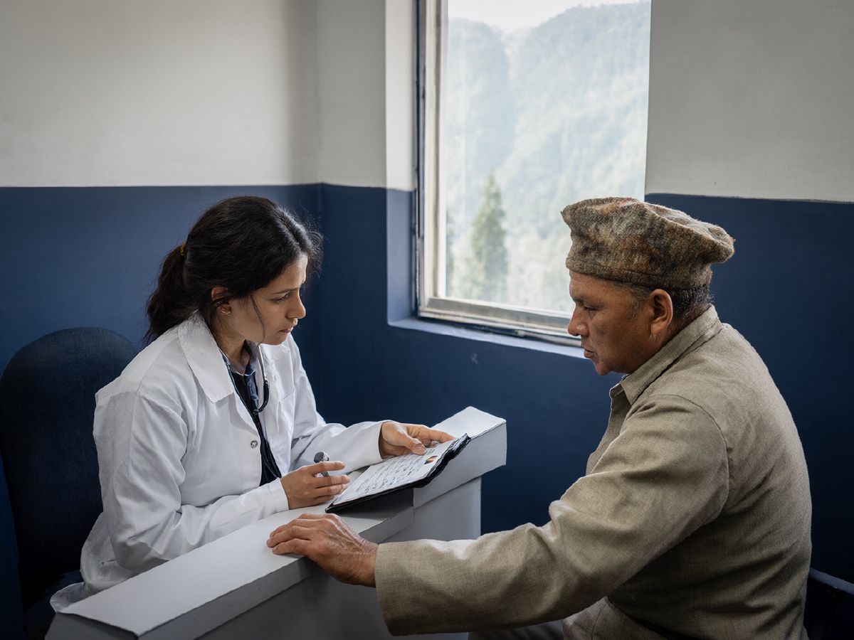 Photo (AI-generated, illustrative): a doctor in a Shimla clinic shows an elderly patient his appointment record on a tablet